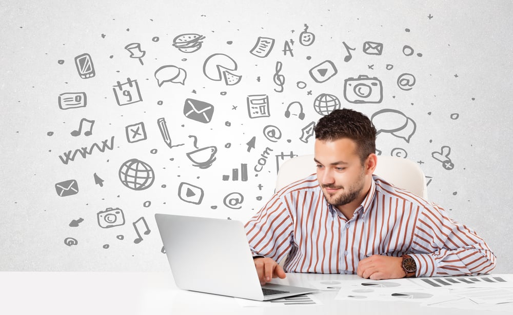 Good-looking young businessman with all kind of hand-drawn media icons in background